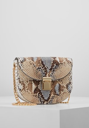 Mała torebka z beżowym i brązowym wzorem skóry węża, złotym prostokątnym zapięciem oraz złotym łańcuszkiem, leżąca na białej powierzchni.