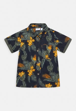 Camisa oscura de manga corta con botones, estampada con hojas tropicales verdes y flores naranjas, que incluye un pequeño bolsillo en el pecho y puños de manga doblados.