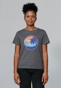 Graues Baumwoll-T-Shirt mit einem runden Grafikdesign, das einen Sonnenuntergang über einem Strand und einem Palmenbaum in Pastellfarben zeigt. Kurzärmlig, mit Rundhalsausschnitt.
