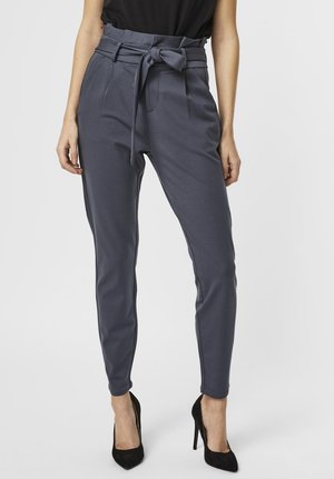 Gray trousers with a tied waist, tapered fit, and prominent side seams. Features pockets and a smooth, stretchy fabric texture.