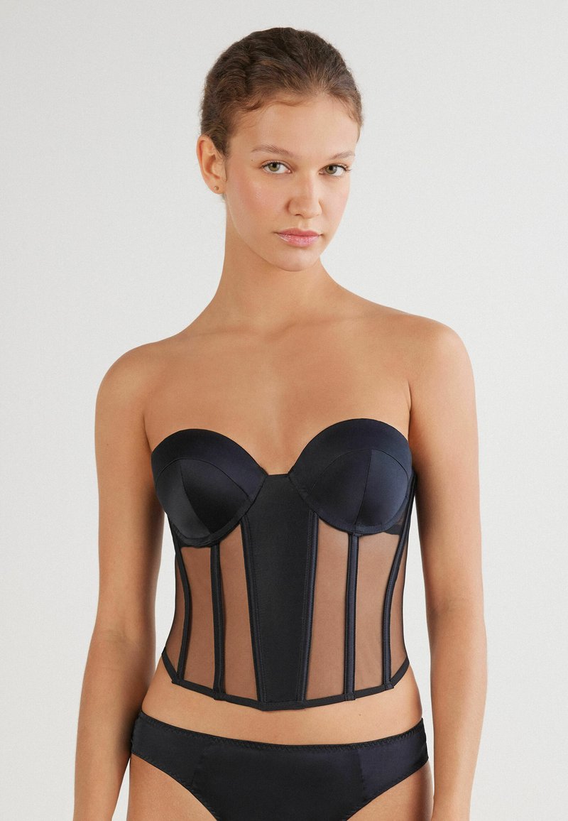 Zwarte bustier met gevoerde cups, doorzichtige gaaspanelen en gestructureerde naden. Gladde satijnen stof, strapless ontwerp met een rechte halslijn.