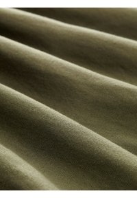Tessuto verde oliva con una superficie liscia, caratterizzato da strati piegati e un sottile motivo di tessitura, che enfatizza profondità e dimensione.
