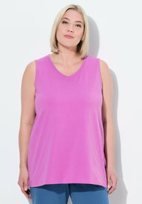 Top senza maniche rosa con scollatura a V, realizzato in tessuto morbido, con una vestibilità comoda e dettagli di cucitura minimi.