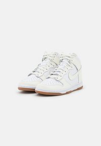 High-top sneakers in white leather with perforated toe box, light gray accents, and gum rubber outsole. Features flat laces and padded collar.