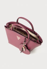 Borsa a tracolla in pelle testurizzata color bordeaux con doppi manici, logo triangolare Guess, zip dorata e portachiavi a forma di cuore.