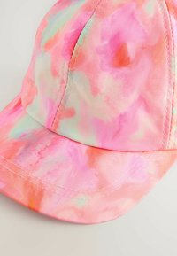Cappellino tie-dye rosa realizzato in morbido tessuto con visiera curva, caratterizzato da dettagli in verde pastello e arancione e cuciture visibili.