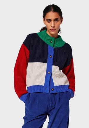 Knit cardigan with a green collar and multi-colored sections: navy, red, white, and blue. Features ribbed texture and button closure.