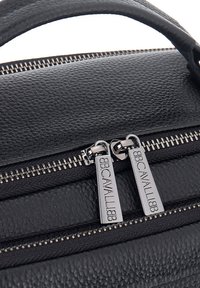 Zwarte leren handtas met textuur, voorzien van zilverkleurige rits hardware, dubbele ritsvoering met gegraveerd merklogo, en een stevige handgreep bovenop.