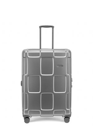 Valise rigide argentée avec poignée télescopique, quatre roues et motifs rectangulaires en relief, marquée du logo "EPIC" à l'avant.
