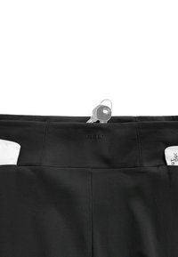 Ceinture en tissu noir avec le nom de la marque "OYSHO," montrant un porte-clés avec deux clés glissées à l’intérieur de la ceinture.