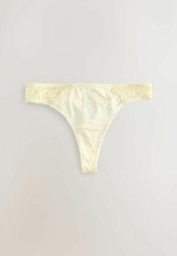 String en soie couleur crème avec détails en dentelle le long de la ceinture sur fond gris clair.