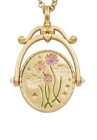 Gouden pendant ketting met een ronde locket met bloemeninscripties in roze en wit, verfraaid met groene stelen en kleine sterren.