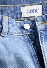 Ceinture de jean en denim avec bouton en métal et fermeture éclair, comportant une étiquette en tissu blanche avec le texte bleu "JJXX".