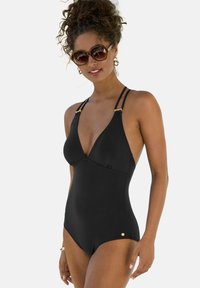 Costume da bagno intero nero con scollatura profonda, spalline sottili, dettagli in hardware dorato e finitura in tessuto testurizzato.