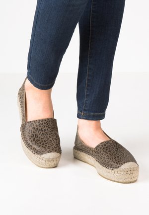 Espadrille shoes in earthy tones featuring a leopard print canvas upper, jutewrapped sole, and a flat design with a rounded toe.
