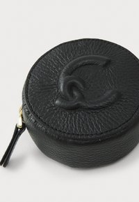 Round black leather coin pouch with textured surface, embossed logo detail, gold hardware zip, and a small attached strap.