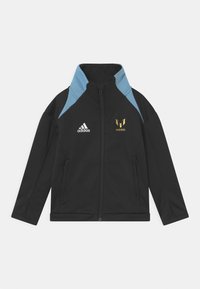 Black softshell jacket with light blue shoulder accents, gold "MÉSSi" logo, Adidas logo on the chest, and zippered side pockets.