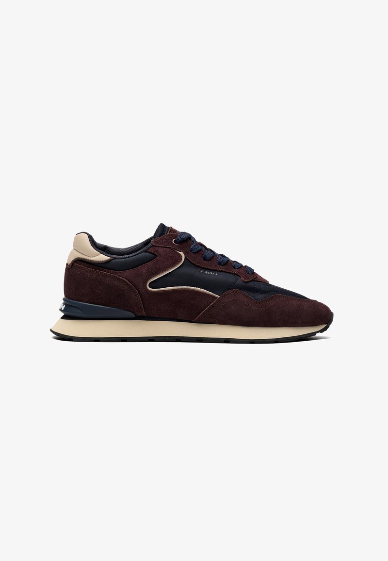 Καφέ και μαύρο σουεντ low-top αθλητικό παπούτσι με μπεζ σόλα και επενδεδυμένο γιακά, από την εξωτερική πλευρά.