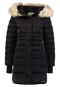 Musta toppatakki, jossa turkilla vuorattu huppu, tikattu muotoilu ja sivutaskut. Varustettu resoreilla hihansuissa ja hillityllä logotarkoituksella helmassa.