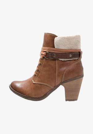 Brown leather ankle boot with a fuzzy collar, lace-up front, and a stacked heeled sole featuring horizontal grooves.