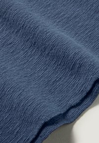Blauer, texturierter Stoff mit einem subtilen Rippenmuster, ausgestattet mit einem weichen, elastischen Gewebe und einem glatten, fallenden Rand.