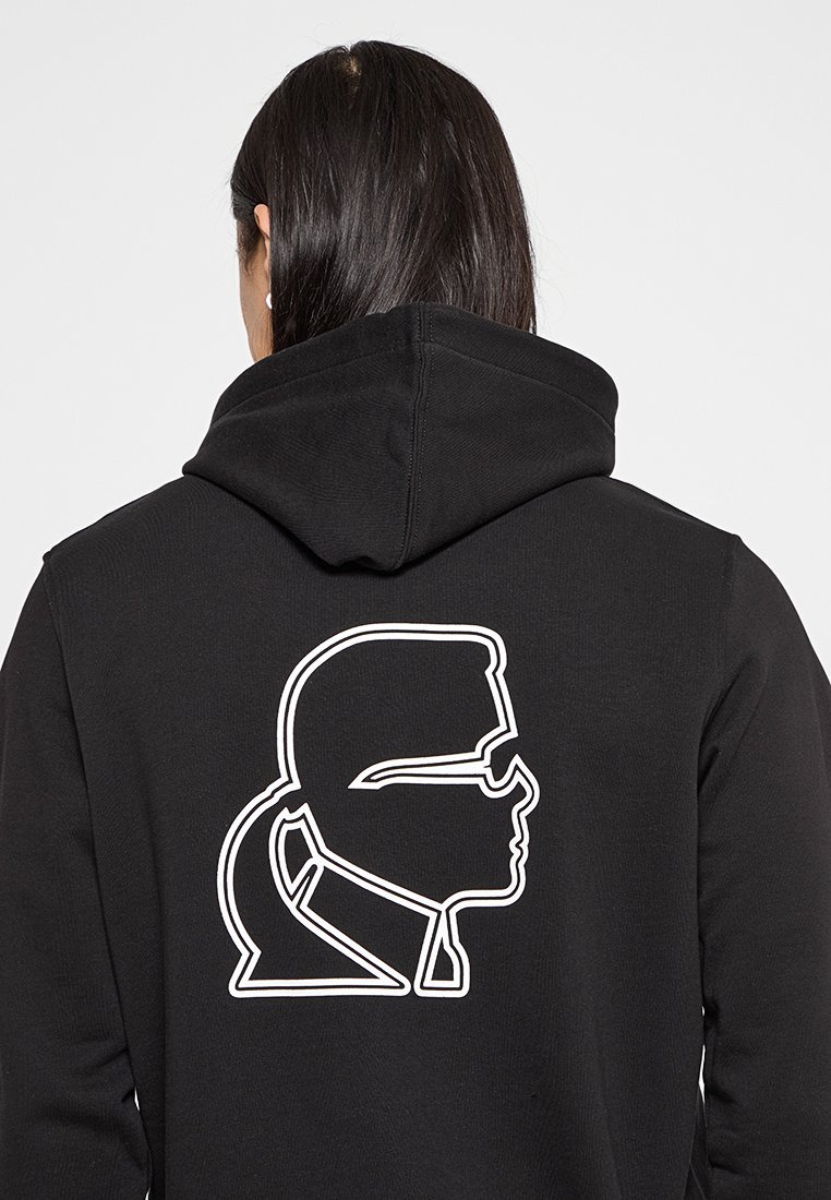Czarna bluza z kapturem z białym konturowym grafiką profilu z tyłu. Materiał jest miękki, ma klasyczny krój i kaptur ze sznurkiem.