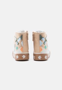 Μπεζ ψηλά αθλητικά παπούτσια για παιδιά με φερμουάρ, διακοσμητική κεντητική πουλιών και φύλλων, και καφέ σόλες με λευκά αποτυπώματα πουλιών.