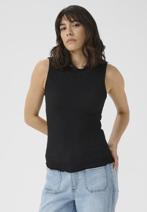 Top nero senza maniche in tessuto testurizzato e stropicciato. Presenta un collo rotondo e una forma aderente, abbinato a jeans azzurri chiari.