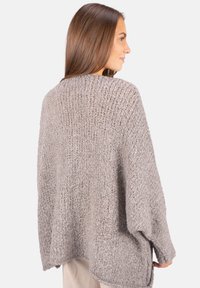 Übergroßer grauer Strickpullover aus einem strukturierten, dicken Garn; verfügt über eine lockere Passform und überschnittene Schultern, die eine entspannte Silhouette bieten.