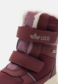 Botas infantiles burdeos con parte superior sintética, forro de felpa, correas de velcro y acentos grises, diseñadas para condiciones invernales.