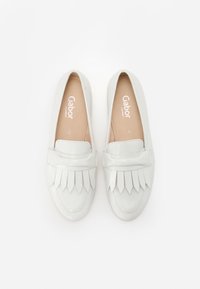 White leather loafers with a flat sole, featuring a fringed design across the front. Soft interior lining with brand logo visible.