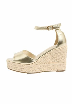 Goldfarbenes Keilsandale aus Metallik mit Knöchelriemen und geflochtenem Plateau-Sohle aus Naturfasern, offenem Zehendesign.