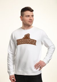 Witte sweatshirt met een grote bruine afbeelding van een beer en het woord "BROWN" er boven. De stof heeft een gladde textuur met geribde manchetten.