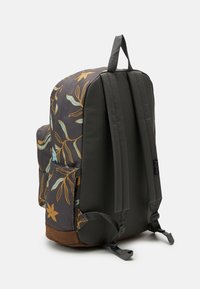 Sac à dos à motif floral gris, doté de bretelles rembourrées, d'une poignée supérieure et d'un fond marron. Comprend des poches latérales pour le rangement.