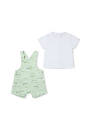 Camiseta blanca de manga corta para niño pequeño con peto corto verde claro con bolsillo y pequeño diseño de texto impreso.