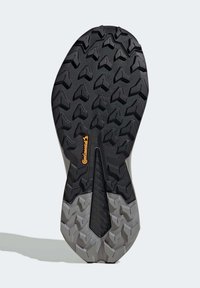 Zwarte rubberen schoenzool met diepe, hoekige profiel voor grip; heeft een centrale groef en grijze accenten; bevat het Continental-logo.