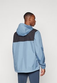 Light blue waterproof jacket with a black yoke design, featuring a hood and elastic cuffs. Smooth texture and casual fit.
