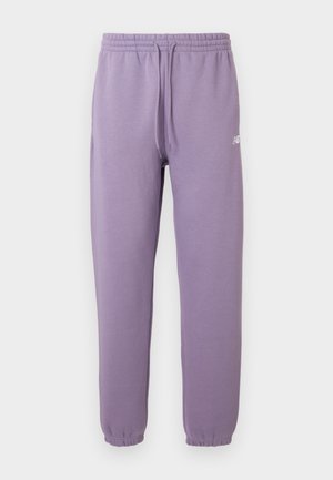 Lilac-colored jogger pants with elastic waistband and ankle cuffs, featuring a small white logo on the left thigh.