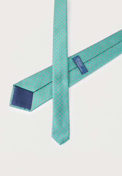 Μια γραβάτα από τιρκουάζ μετάξι με μικρά κόκκινα και λευκά λουλουδένια σχέδια, που δείχνει την ετικέτα Polo by Ralph Lauren και επένδυση σε σκούρο μπλε στο πίσω μέρος.