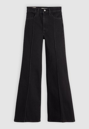 Jeans noires taille haute évasés avec coutures frontales, cinq poches, passants de ceinture et fermeture à bouton sur fond gris clair.