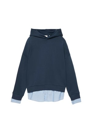 Sweat à capuche bleu marine porté par-dessus les poignets et l'ourlet d'une chemise à rayures bleu clair et blanc boutonnée.