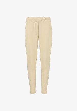 Kermanväriset, joustavat college-housut, joissa on joustava vyötärö, kapenevat lahkeet ja sileä pinta. Ei näkyviä kuvioita tai yksityiskohtia.