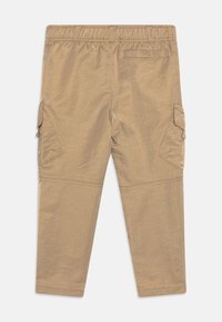 Béžové cargo kalhoty s elastickým páskem, dvěma postranními kapsami a jednou zadní kapsou. Vyrobeny z lehké, texturované látky.