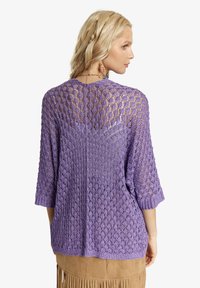 Violet atviras megztinis su 3/4 rankovėmis ir laisvu siluetu. Su deimanto raštu ir tekstūrine apdaila. Sukurtas kasdieniam dėvėjimui.
