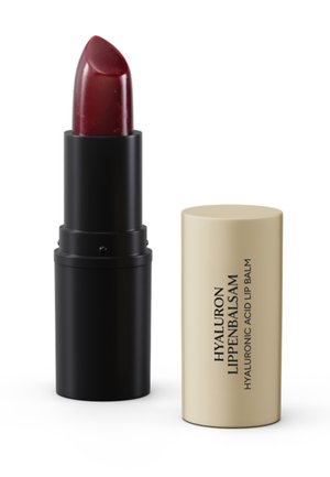Dark red lipstick with black base standing next to beige cap labeled "Hyaluron Lippenbalsam Hyaluronic Acid Lip Balm" on white background.