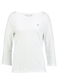 Weißes Langarmshirt mit Rundhalsausschnitt und kleinem Tommy Hilfiger-Logo auf der linken Brust.