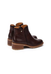 Botas de tobillo de cuero marrón con un acabado suave, cremallera lateral, detalle de costura prominente y un tacón de madera apilada.