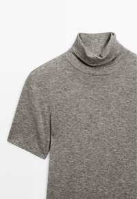 Gray turtleneck top made of soft, textured fabric. Features short sleeves and a rolled collar, with a plain design and subtle heather pattern.