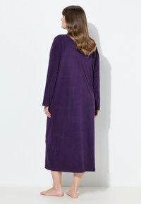 Dlouhý fialový plášť vyrobený z měkké tkaniny, s dlouhými rukávy a dlouhým střihem s jednoduchým a čistým designem. Žádné vzory ani ozdoby.