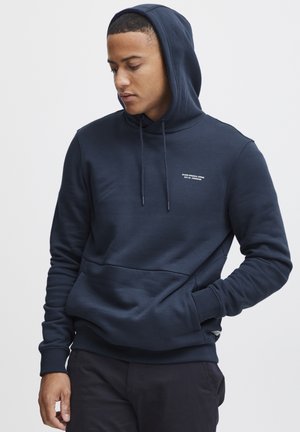 Felpa con cappuccio blu navy in tessuto morbido, dotata di tasca a marsupio frontale, cappuccio con lacci e un piccolo logo bianco sul petto.